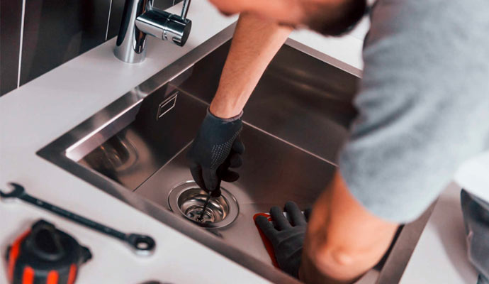 Kitchen leak being repaired by a worker 