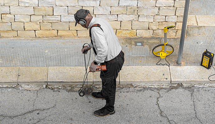 Worker detecting sewer leak