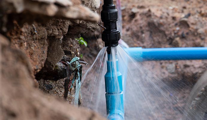 water pipe leak exposing a burst water spraying water and the pipe