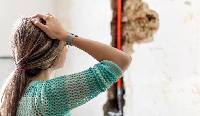 woman looking at damage water pipe leak